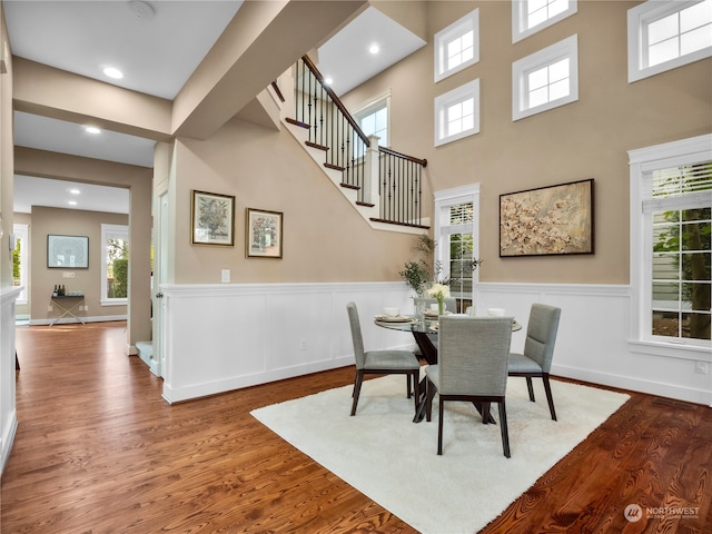 dining area featuring hardwood / wood-style floors and a high ceiling