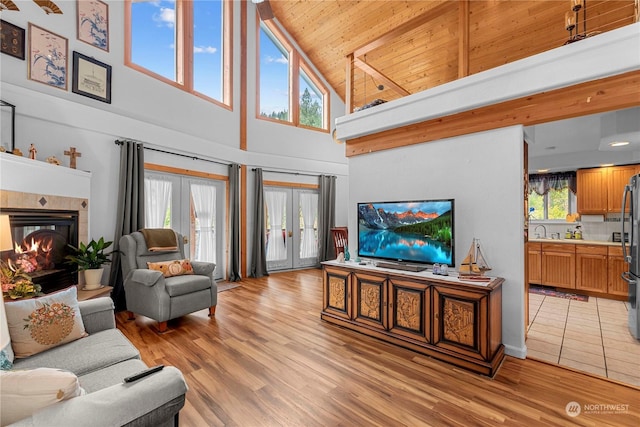 456 Hinthorne Ln, Leavenworth, WA 98826 - living room with high vaulted ceiling, wooden ceiling, a tiled fireplace, french doors, and plenty of natural light