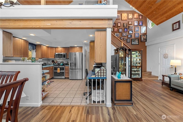 456 Hinthorne Ln, Leavenworth, WA 98826 - kitchen with stainless steel appliances, brown cabinetry, light wood-style flooring, high vaulted ceiling, and wood ceiling