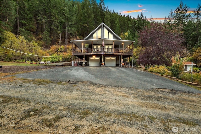 456 Hinthorne Ln, Leavenworth, WA 98826 - view of front of house with asphalt driveway, an attached garage, and a wooded view