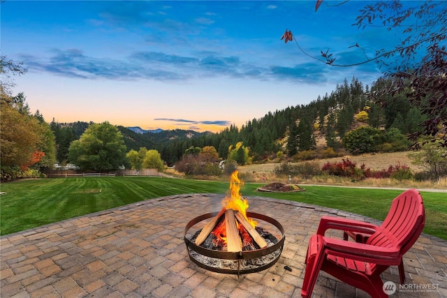 456 Hinthorne Ln, Leavenworth, WA 98826 - patio terrace at dusk with a fire pit, a patio, and a lawn