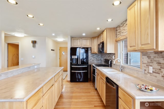 kitchen with light brown cabinetry, sink, light hardwood / wood-style flooring, and black appliances