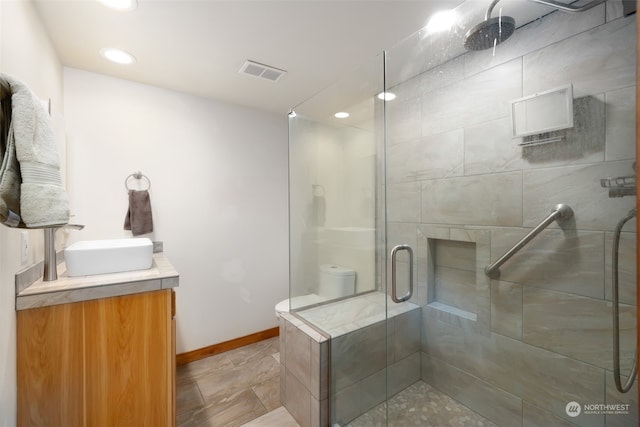 bathroom with vanity, toilet, and walk in shower