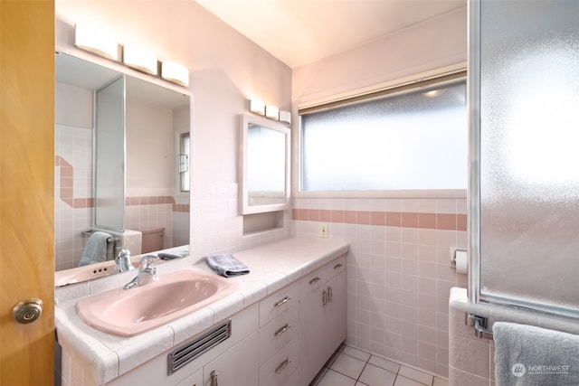 bathroom with tile patterned flooring, vanity, and tile walls