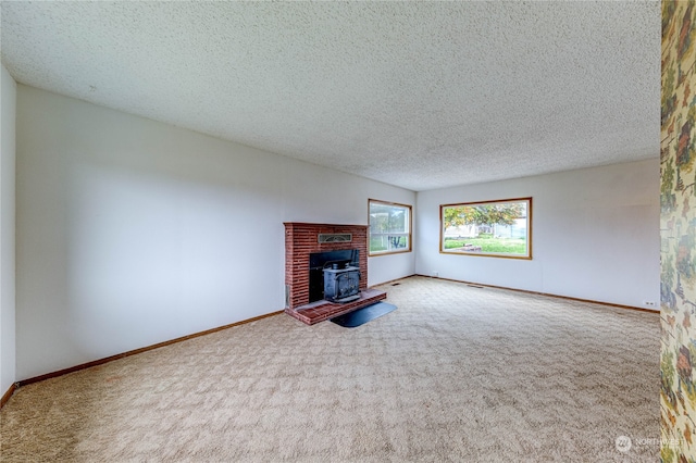 unfurnished living room with a textured ceiling, a wood stove, and carpet floors