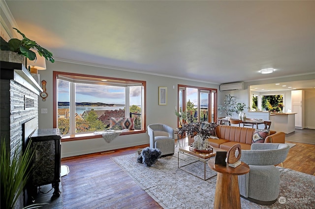 living room with a wall mounted AC, a stone fireplace, wood-type flooring, and ornamental molding