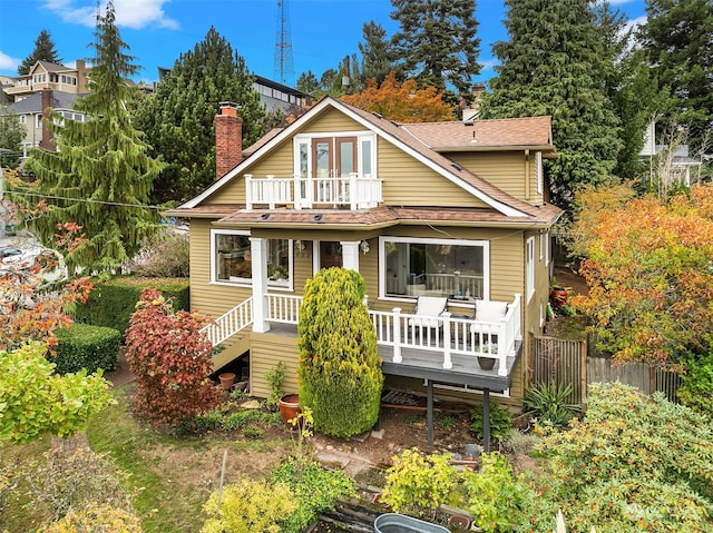 rear view of house featuring a wooden deck and a balcony