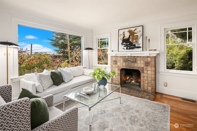 living room featuring hardwood / wood-style flooring, plenty of natural light, and a tile fireplace