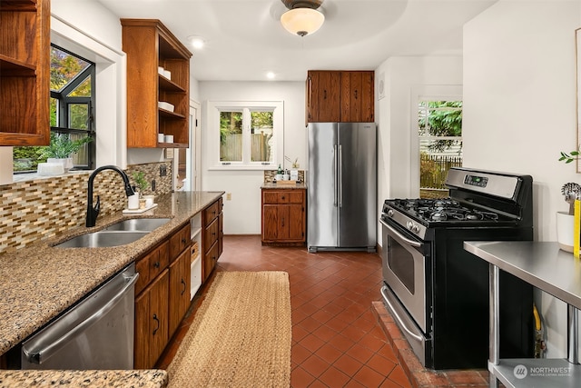 kitchen featuring a wealth of natural light, sink, stainless steel appliances, and backsplash