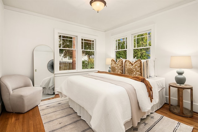 bedroom featuring crown molding and light wood-type flooring