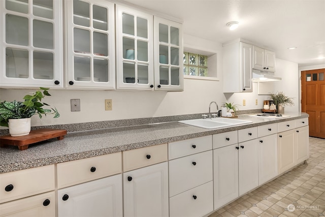 kitchen featuring white cabinetry, light tile patterned flooring, sink, and white stovetop