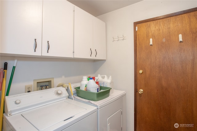 clothes washing area featuring washing machine and dryer and cabinets