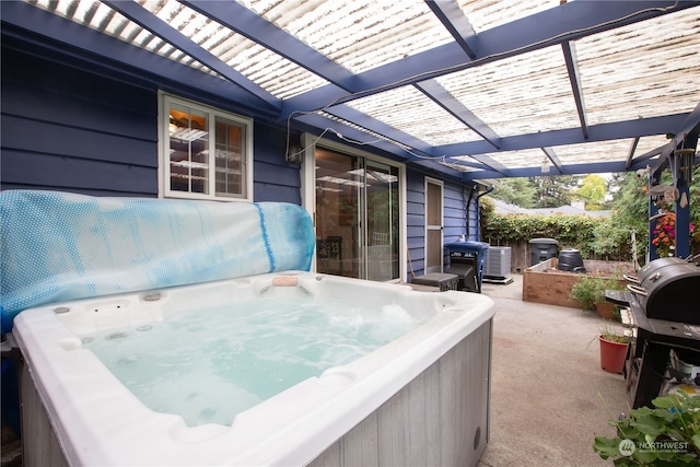 view of patio / terrace with a hot tub and a pergola