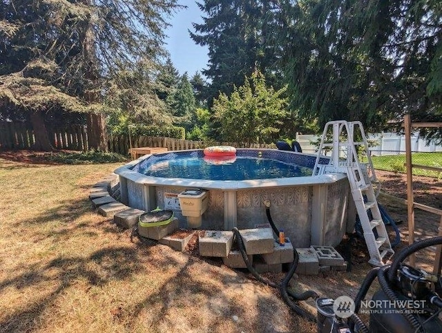 view of swimming pool with a lawn