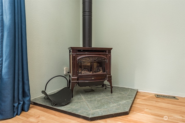 interior details with hardwood / wood-style flooring and a wood stove