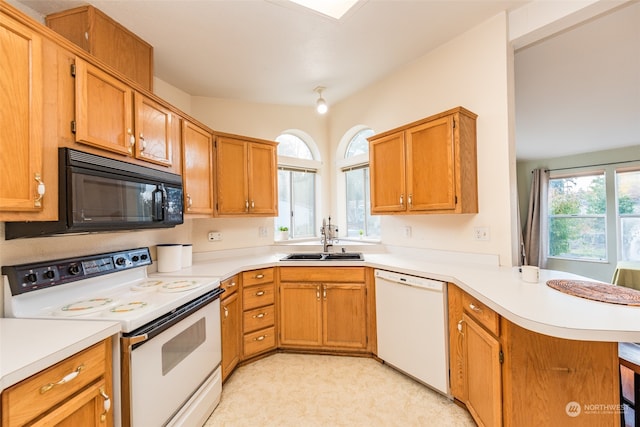 kitchen featuring kitchen peninsula, sink, and white appliances