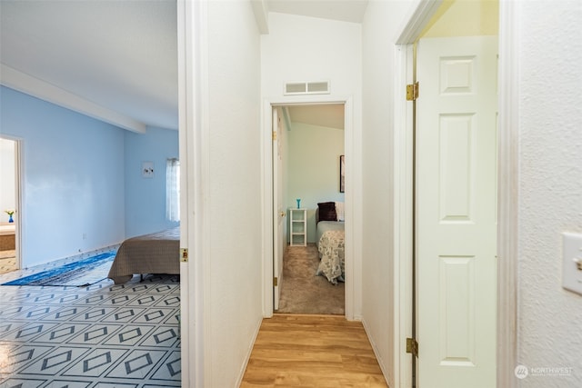 hall featuring light hardwood / wood-style floors and vaulted ceiling