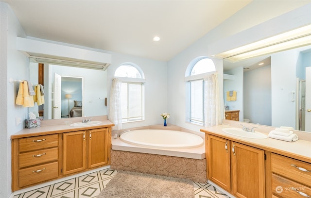 bathroom with vanity, a relaxing tiled tub, tile patterned floors, and vaulted ceiling