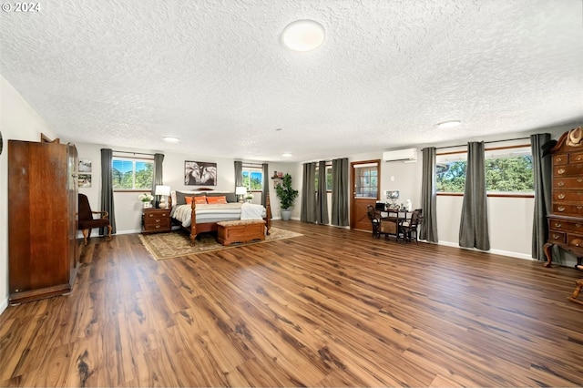 unfurnished bedroom featuring a wall mounted air conditioner, hardwood / wood-style floors, and a textured ceiling