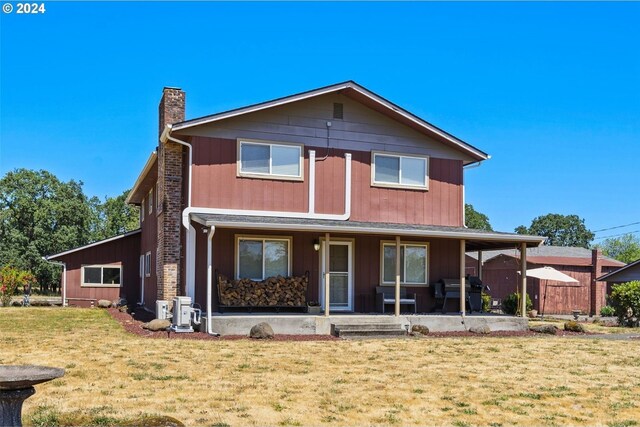 back of property featuring a porch and a yard