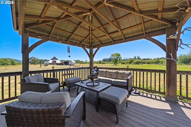 wooden terrace featuring a yard, a gazebo, a rural view, and an outdoor living space