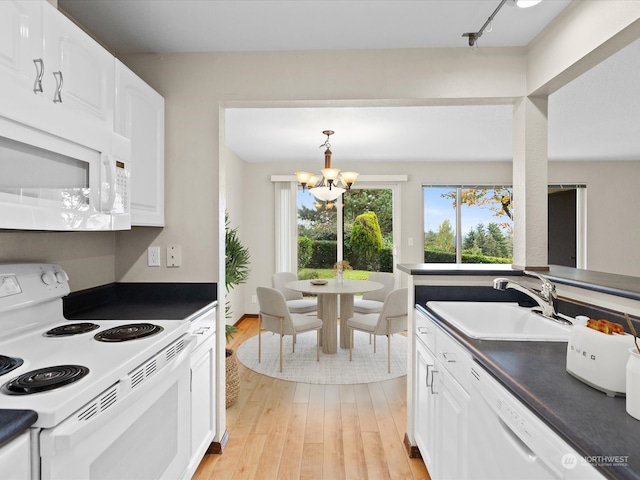 kitchen featuring white appliances, light hardwood / wood-style floors, a notable chandelier, and white cabinetry