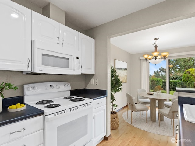 kitchen with white appliances, hanging light fixtures, white cabinetry, light hardwood / wood-style floors, and a chandelier