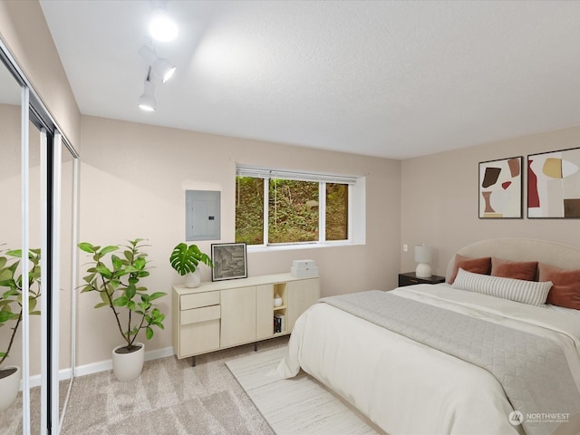 bedroom featuring light carpet, a textured ceiling, and electric panel