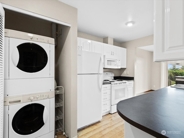 kitchen with light hardwood / wood-style flooring, white cabinets, stacked washer / drying machine, and white appliances