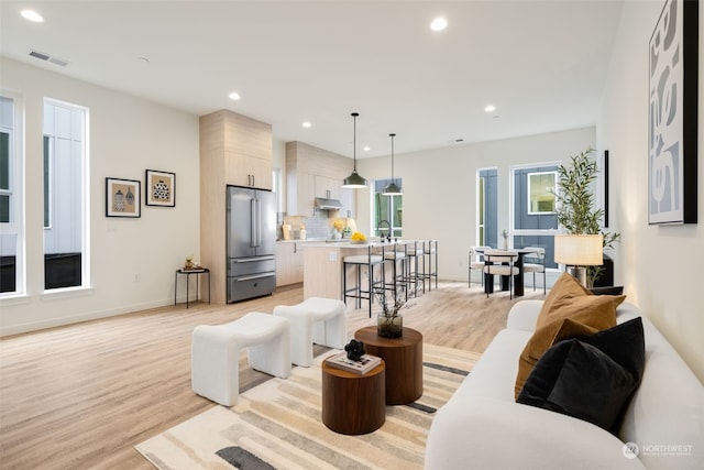 living room with sink and light wood-type flooring