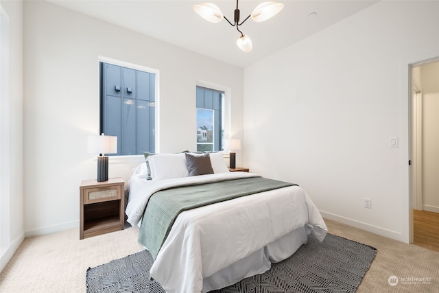 bedroom featuring a chandelier and light colored carpet