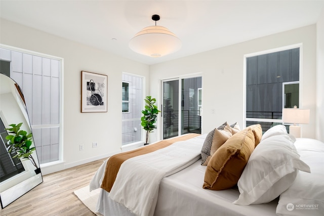 bedroom with access to outside and light wood-type flooring