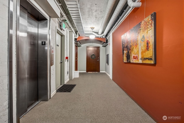 hall with carpet floors and elevator