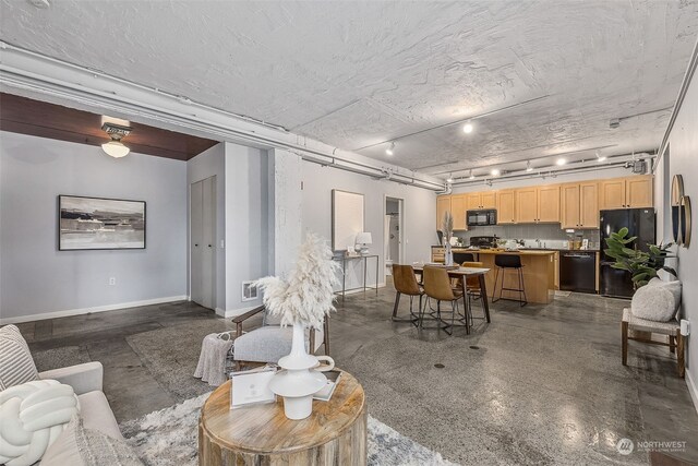 744 Market St Unit 202, Tacoma, WA 98402 - living area with rail lighting, baseboards, and finished concrete floors
