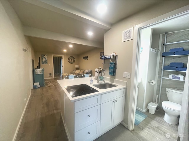 kitchen with black electric cooktop, white cabinetry, hardwood / wood-style flooring, and sink