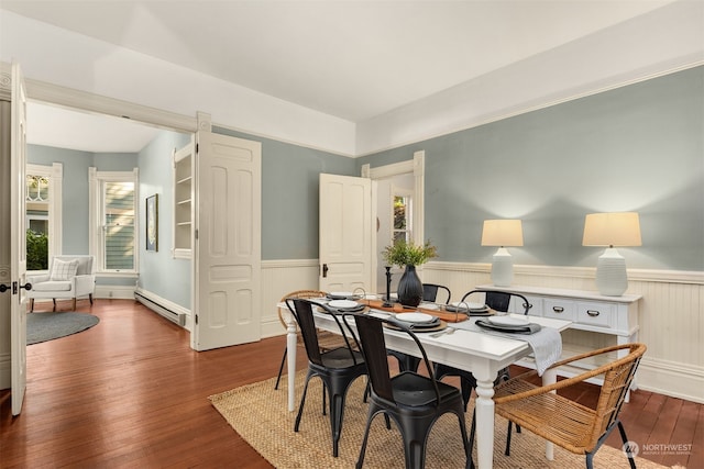 dining area with a baseboard heating unit and wood-type flooring