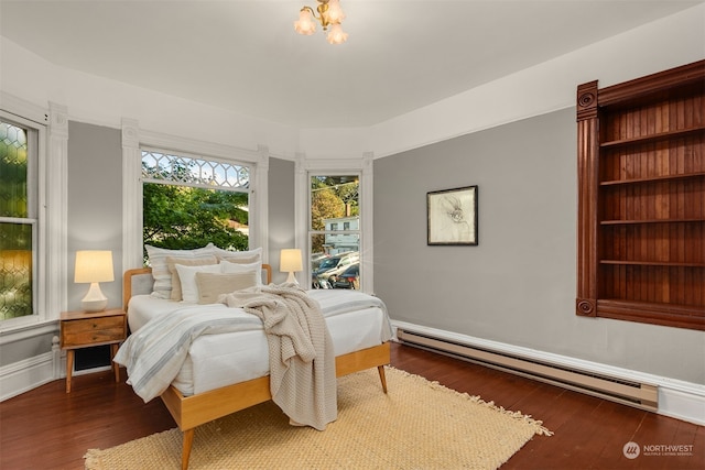 bedroom with dark wood-type flooring and a baseboard heating unit