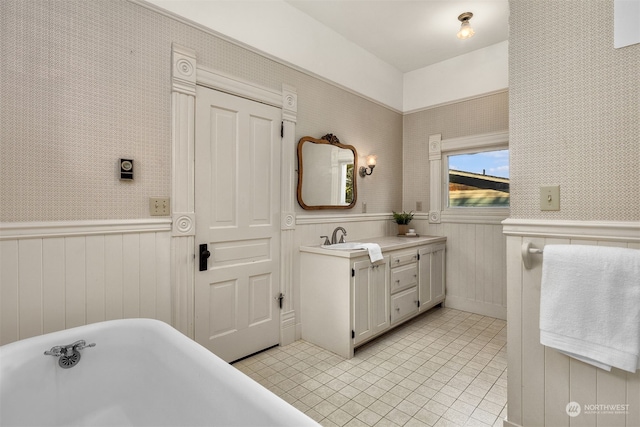 bathroom featuring vanity, wooden walls, tile patterned floors, and a bathtub