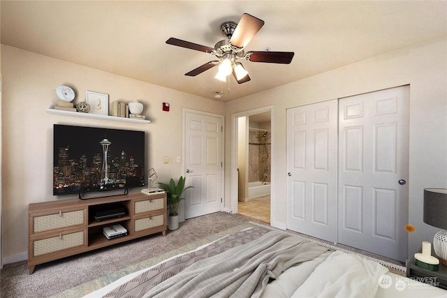 carpeted bedroom featuring a closet, connected bathroom, and ceiling fan