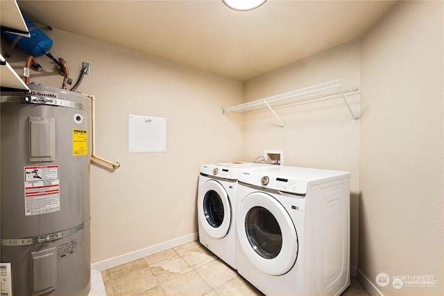 clothes washing area with separate washer and dryer and strapped water heater