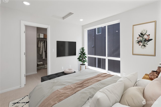 bedroom featuring light carpet, a spacious closet, and a closet