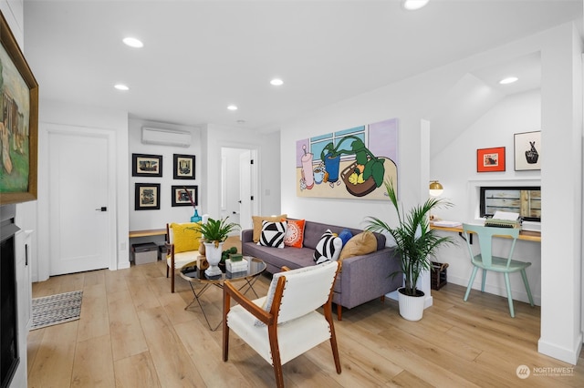 living room featuring light hardwood / wood-style floors, an AC wall unit, vaulted ceiling, and built in desk