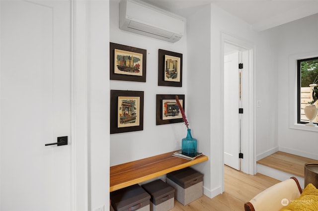 hallway featuring light hardwood / wood-style floors and a wall mounted AC