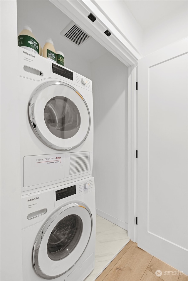 clothes washing area featuring stacked washer / dryer