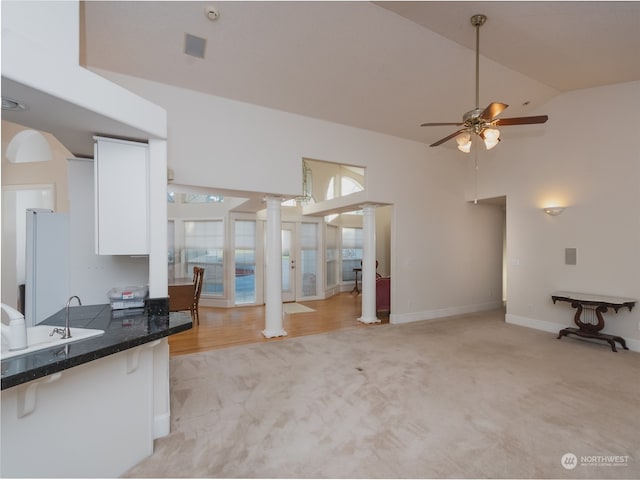 kitchen featuring white cabinets, ceiling fan, decorative columns, white fridge, and light colored carpet