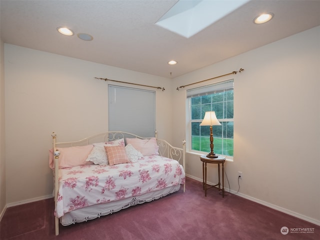 bedroom with a skylight and dark colored carpet