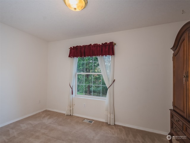 unfurnished room featuring light colored carpet