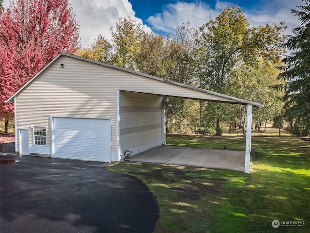 garage featuring a yard and a carport