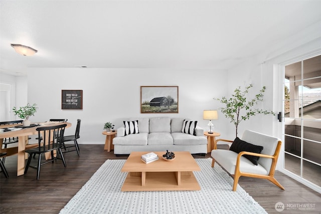 living room featuring dark wood-type flooring, visible vents, and baseboards