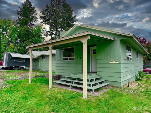 rear view of property featuring a lawn